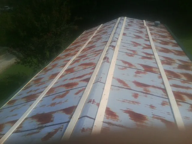 Rusted metal roof panels with new wood purlins before replacement — Storm Damage Roof Repair in Shedd by Roofing Brothers