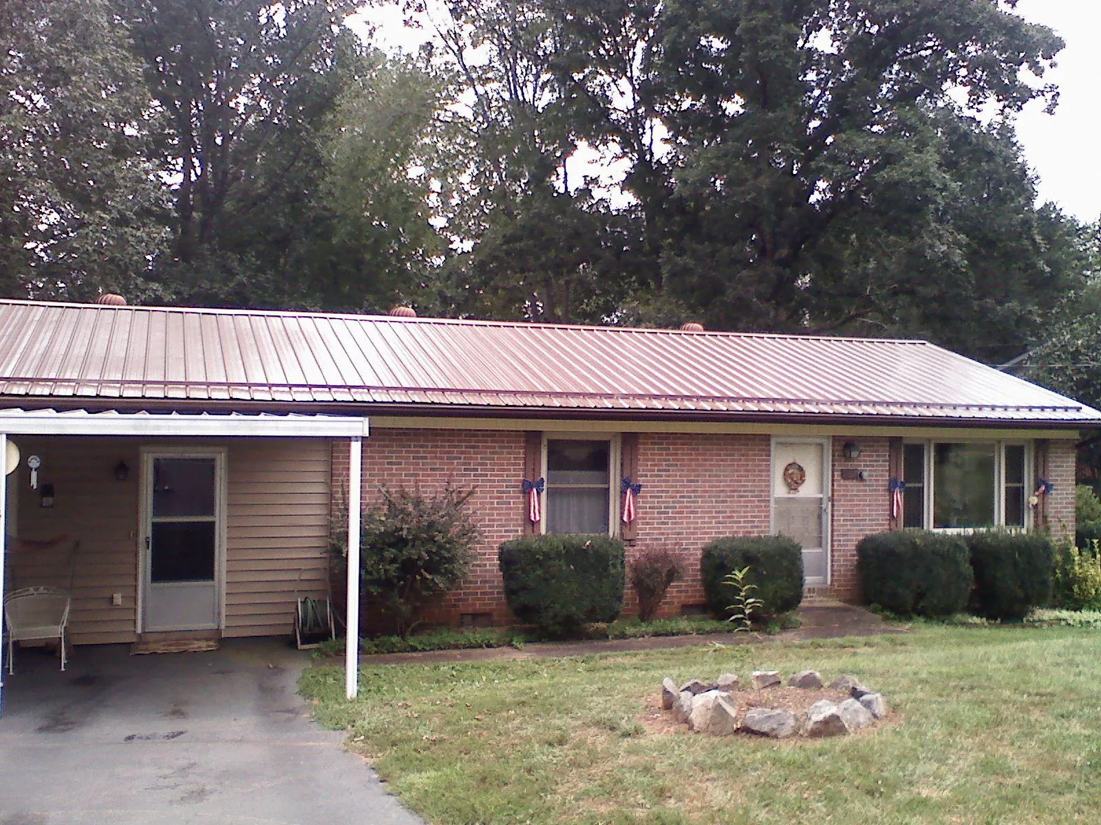 Bronze metal roof and carport on a brick ranch home — Roof Repair work by our crew in Shedd